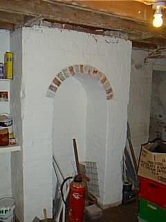 Cellar room 1 showing arch under fireplace.